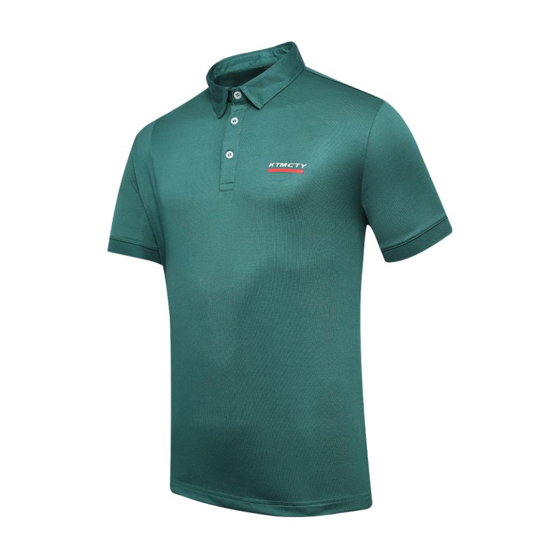 A man styling the forest green KTM CTY Pulse athletic polo tshirt, featuring a classic buttoned collar and short sleeves, paired comfortably with casual grey trousers 4