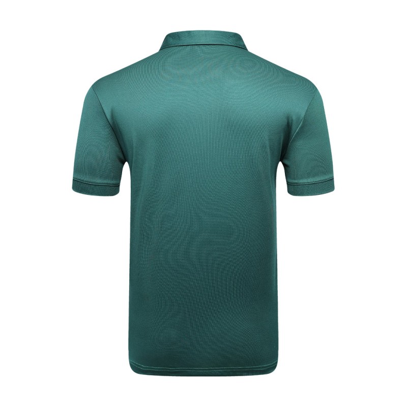 A man styling the forest green KTM CTY Pulse athletic polo tshirt, featuring a classic buttoned collar and short sleeves, paired comfortably with casual grey trousers 5