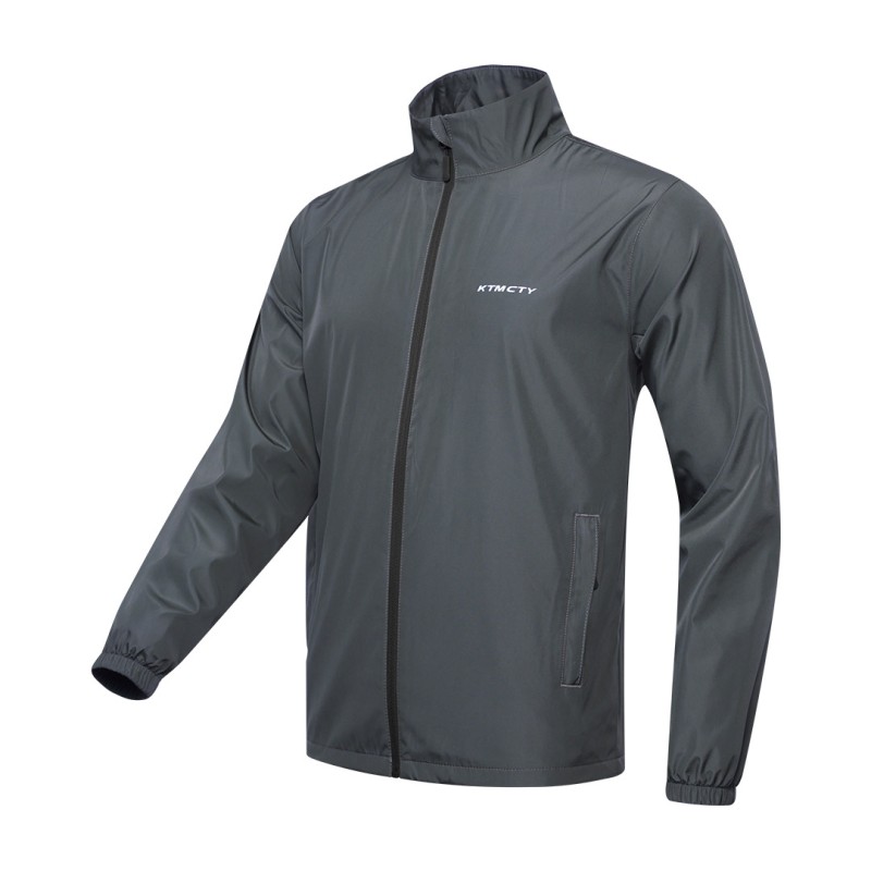 A male model wearing sunglasses looks off to the side while adjusting the collar of his olive green KTM CTY windbreaker, windcheater. The lightweight windguard jacket features a full-zip front, elastic cuffs, and a small white logo on the chest 2