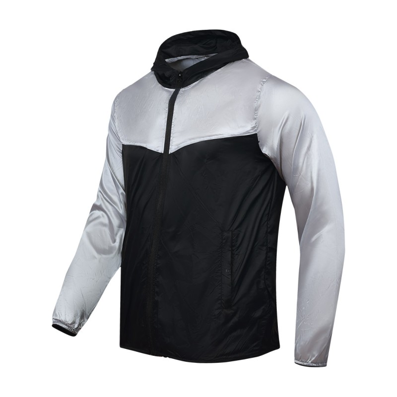 Front view of a male model styling a vibrant red and blue color-block lightweight windcheater jacket. This casual Unisex Windbreaker Jacket features a full zipper and a protective hood, making it a great outer layer for summer wear jacket. 2