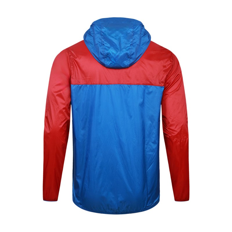 Front view of a male model styling a vibrant red and blue color-block lightweight windcheater jacket. This casual Unisex Windbreaker Jacket features a full zipper and a protective hood, making it a great outer layer for summer wear jacket. 7