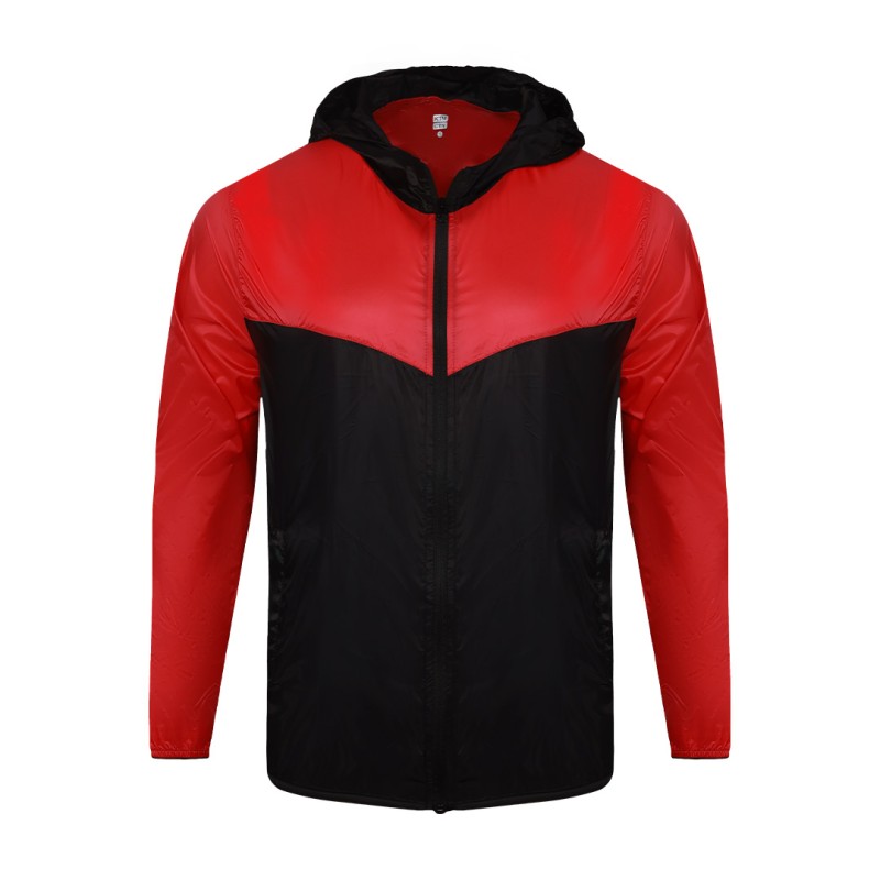 Front view of a male model styling a vibrant red and blue color-block lightweight windcheater jacket. This casual Unisex Windbreaker Jacket features a full zipper and a protective hood, making it a great outer layer for summer wear jacket. 4