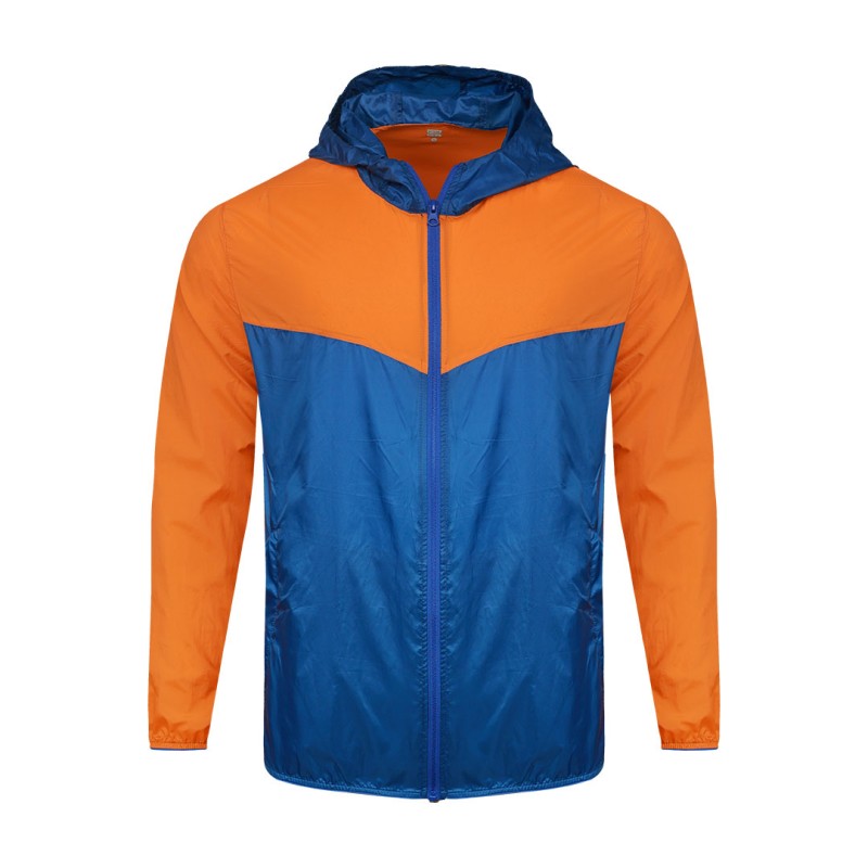 A smiling male model wearing the lightweight SkyShield Windcheater Jacket, featuring a bold red and bright blue color-block design, a full front zipper and an adjustable hood 0