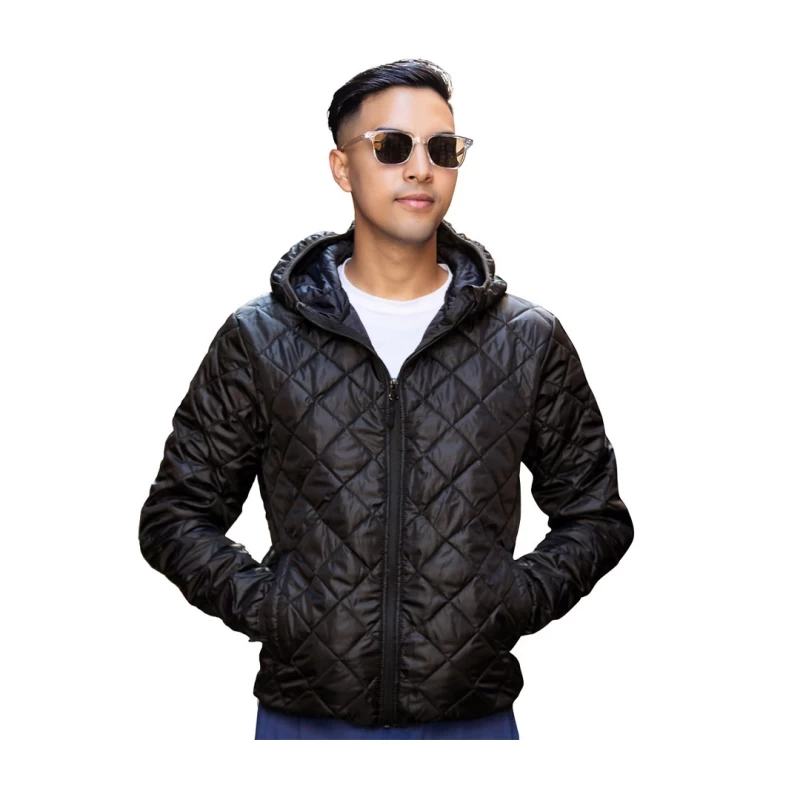 A model wearing a black unisex polyfiber hooded jacket featuring a classic diamond-quilted pattern, a full front zipper, and hands resting comfortably in the side pockets